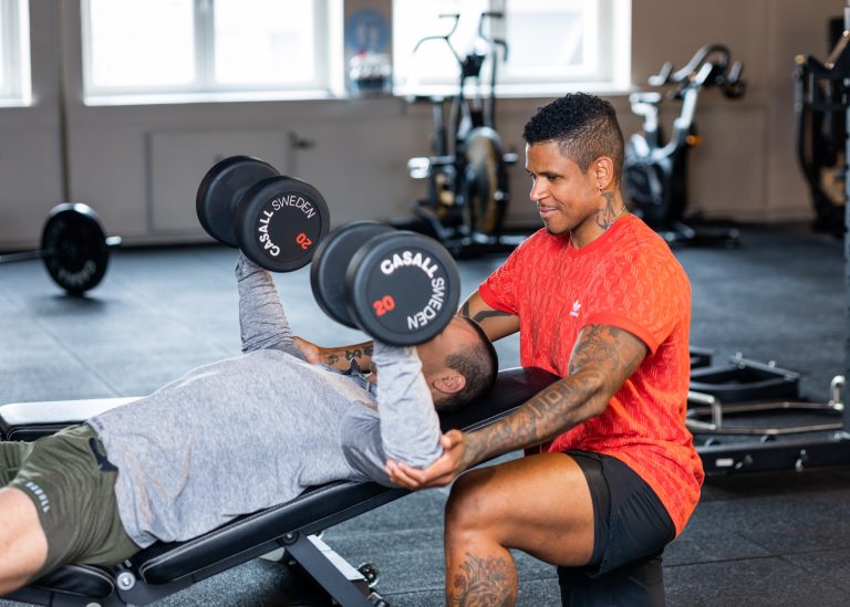 Personlig trener hjelper en kunde i gymmet